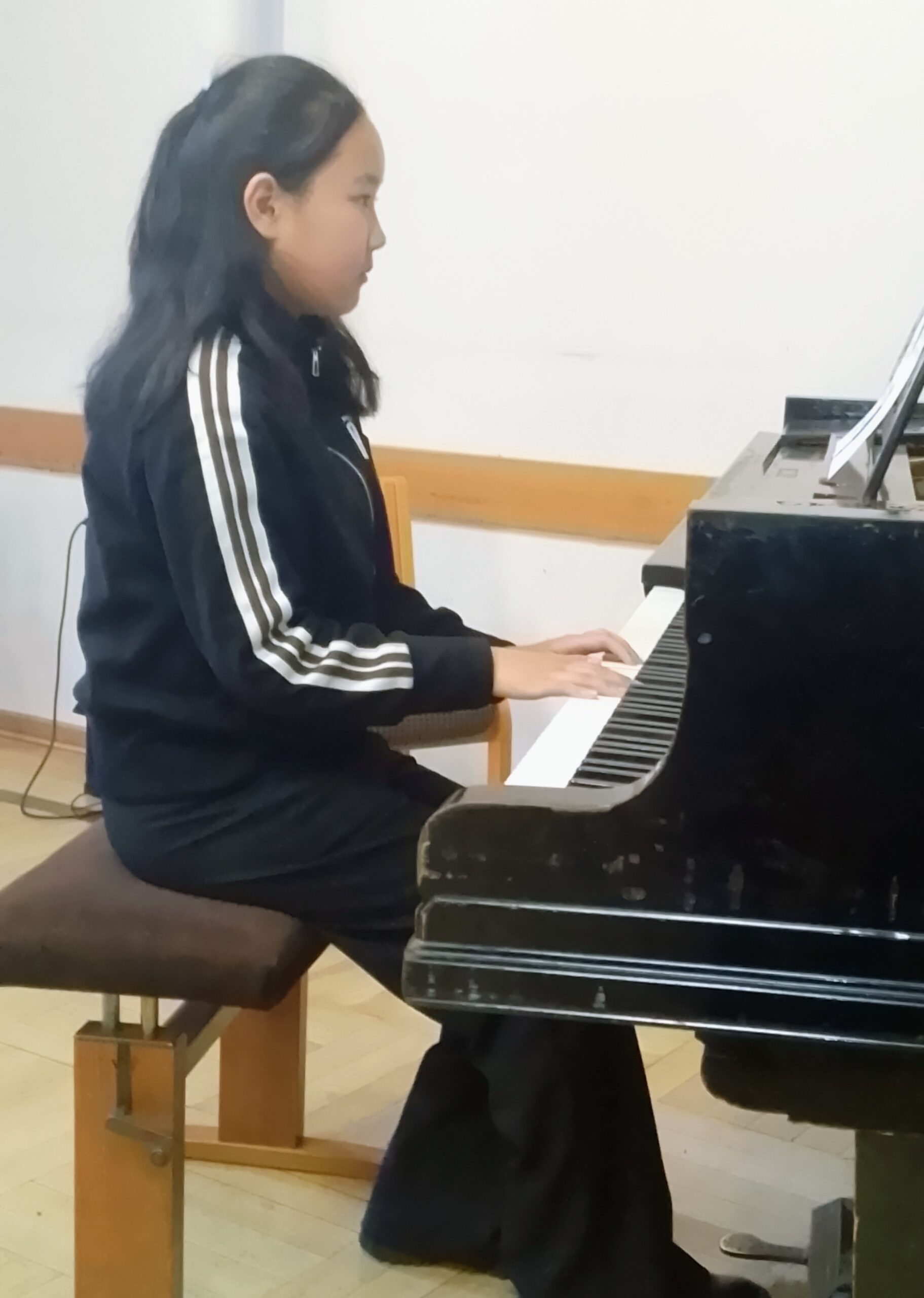 Schwarzhaariges Mädchen am Klavier beim Konzert Filmmusik der Kreismusikschule Göttingen